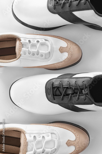 Two pairs of leather golf shoes on white background photo