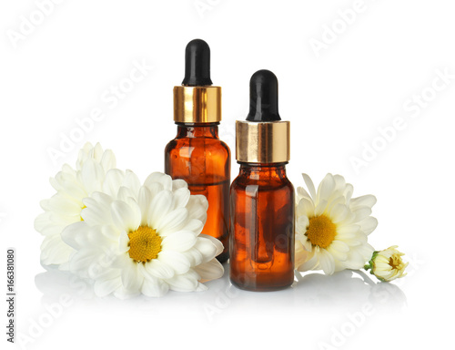 Wallpaper Mural Bottles of essential oil and chamomile flowers on white background Torontodigital.ca