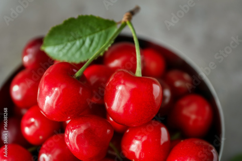 Bowl with fresh ripe cherries on grey background