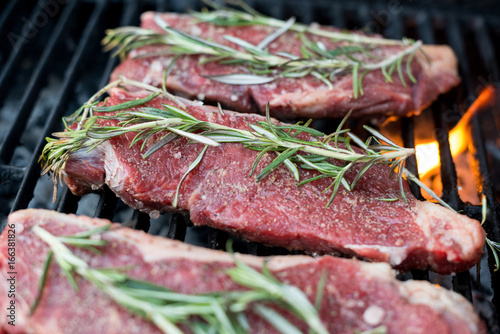 Raw New York Strip Steaks on Barbecue photo