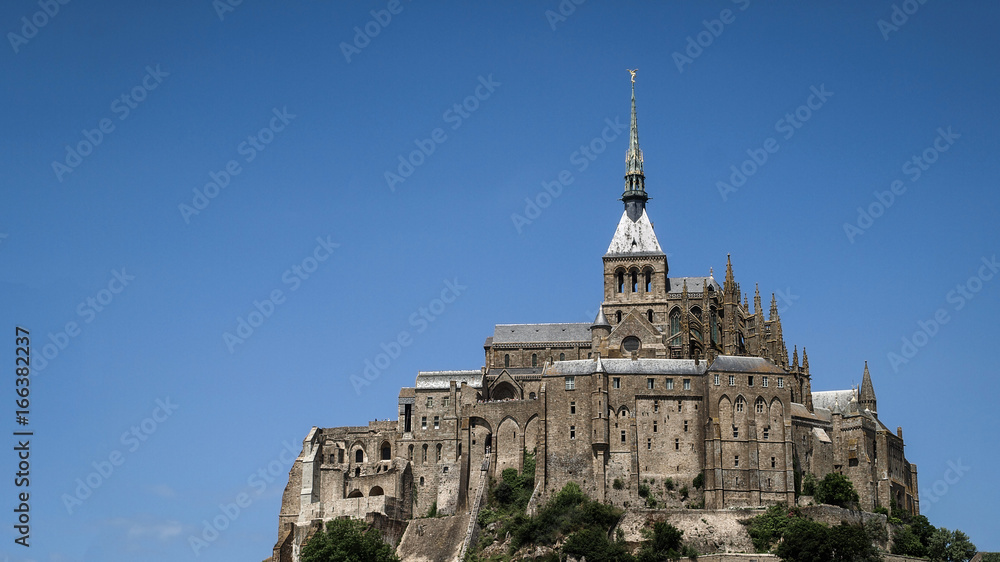 Panoramic view of Mont-Saint-Michel monastery with blue sky in the background.France, Europe.