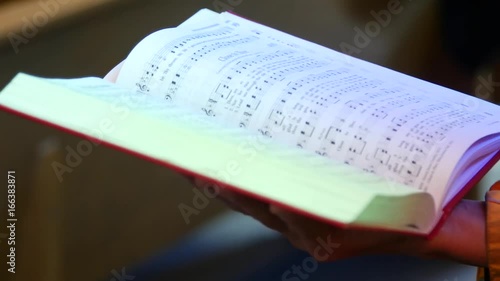 A parishioner holds a hymn book open. photo