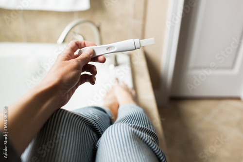 woman holding a pregnancy test photo