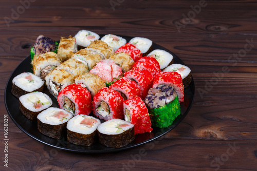 Фотография Colorful set of japanese sushi maki rolls with salmon, tuna and avocado served o