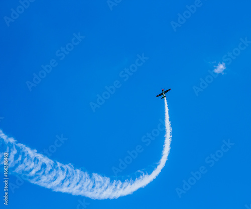 Спортивный самолет в небе и след от него