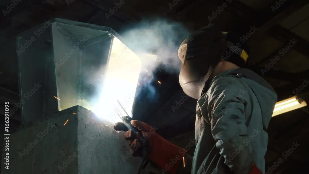 Welder welds the parts of the structure. Manufacture of reinforced concrete structures. Welding is an integral part of the technological process. Welder welds the parts of the structure. Manufacture of reinforced concrete structures. Welding is an integral part of the technological process.