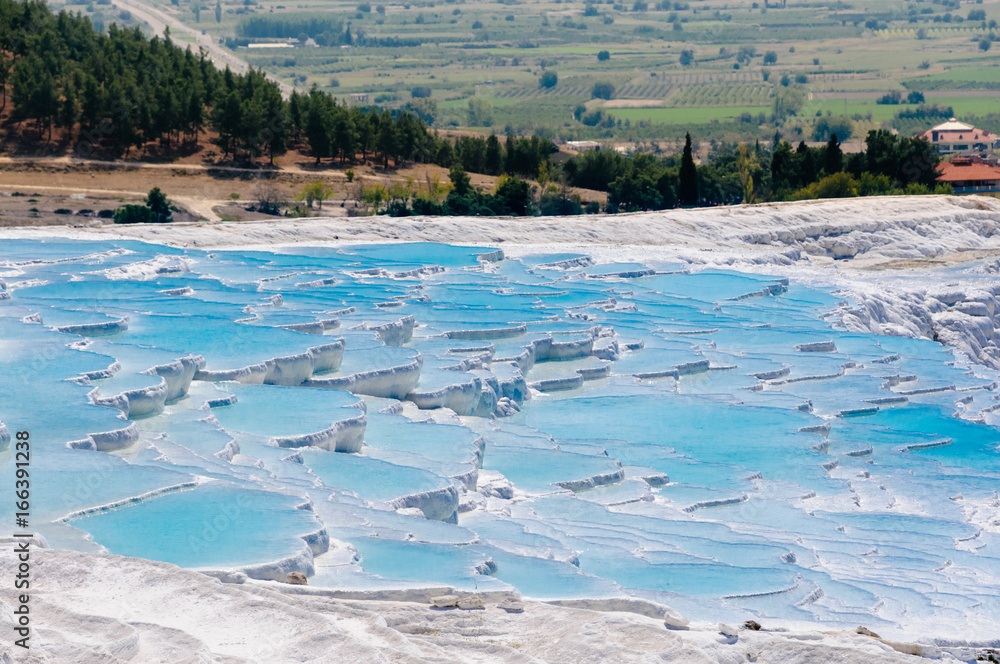 White travertines of calcium carbonate deposits at the Pamukkale natural thermal springs in Turkey.