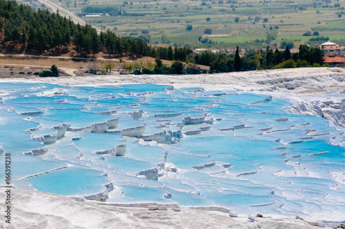 White travertines of calcium carbonate deposits at the Pamukkale natural thermal springs in Turkey.