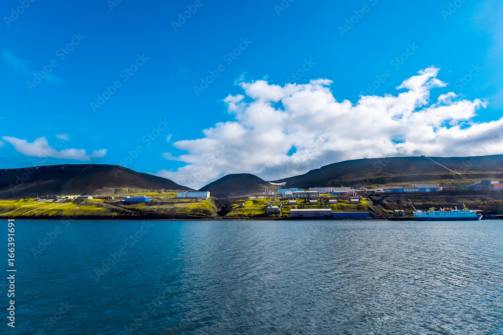 Landscape of the Russian  city of Barentsburg on the Spitsbergen archipelago in the summer in the Arctic In sunny weather and blue sky