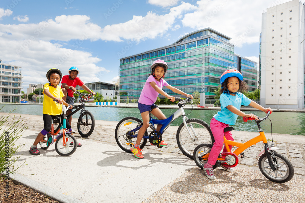 Naklejka premium African children enjoying cycling together in town