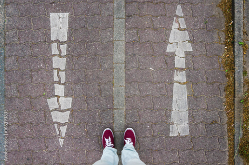 Arrows going up and down, red sneakers, footsie, personal perspective photo