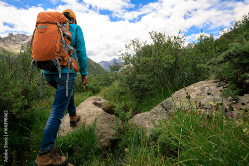 young backpacking woman hiking in mountains