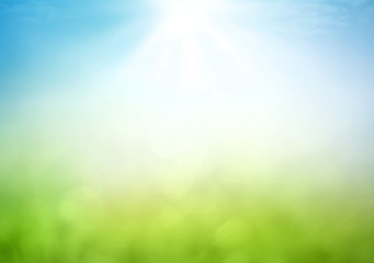 Earth Day concept with abstract blurred nature background in green grass and blue sky with sun light and bokeh for environmental conservation and sustainability