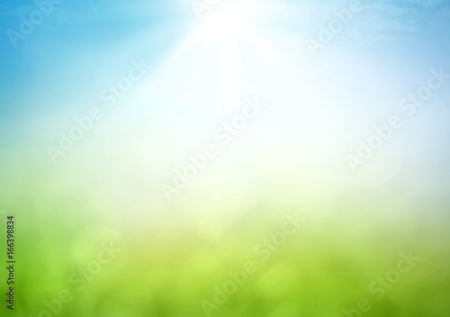 Earth Day concept with abstract blurred nature background in green grass and blue sky with sun light and bokeh for environmental conservation and sustainability with copy space