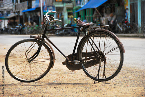 Old bicycle standing on a street.