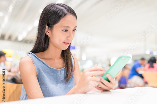 Woman using mobile phone in restaurant