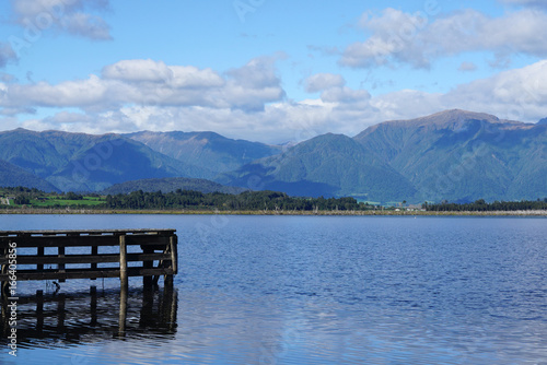 Wooden jetty into the lake with mountain range background