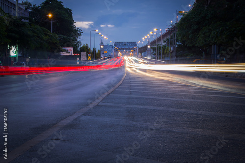 Traffic on city road through the bridge at twilight in Thailand. Long exposure shot photography by DSLR camera.