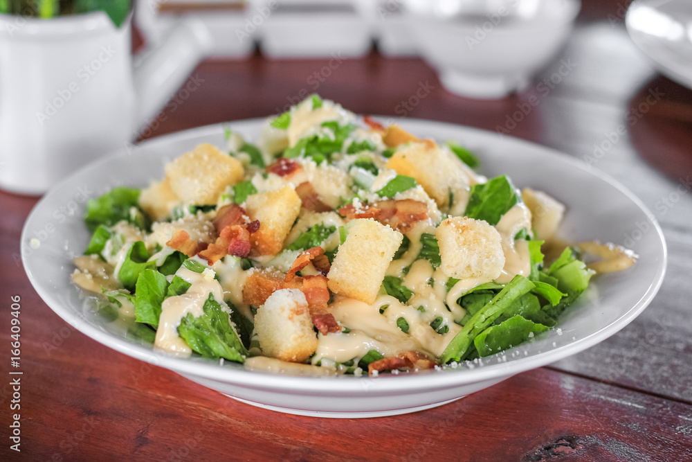 Fresh healthy caesar salad on wooden table Fresh healthy caesar salad on wooden table