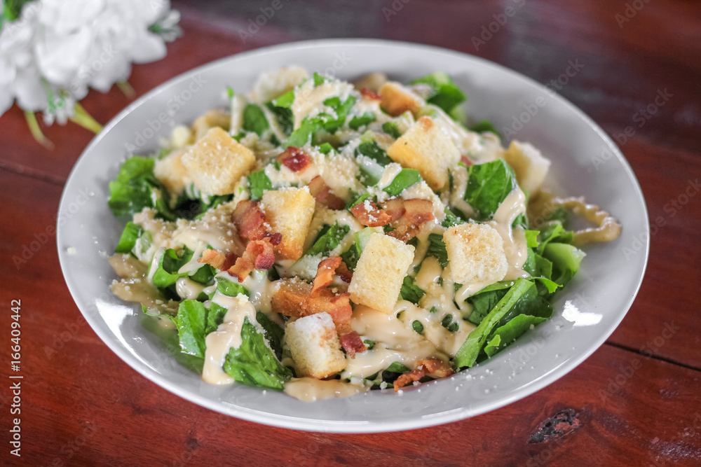Fresh healthy caesar salad on wooden table Fresh healthy caesar salad on wooden table