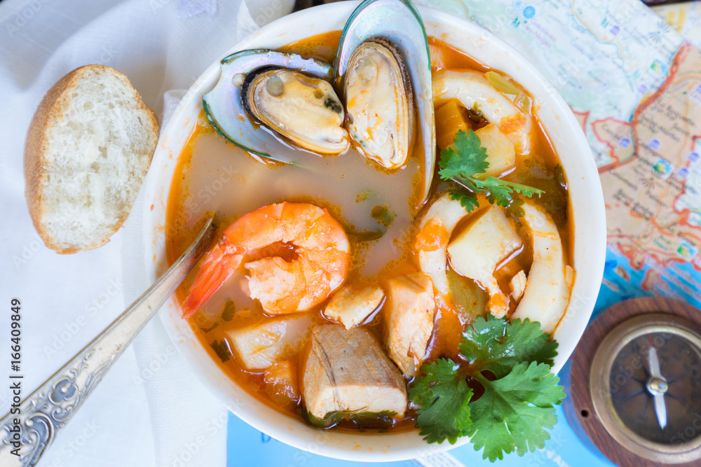 Bowl of Bouillabaisse french seafood soup with bread close up