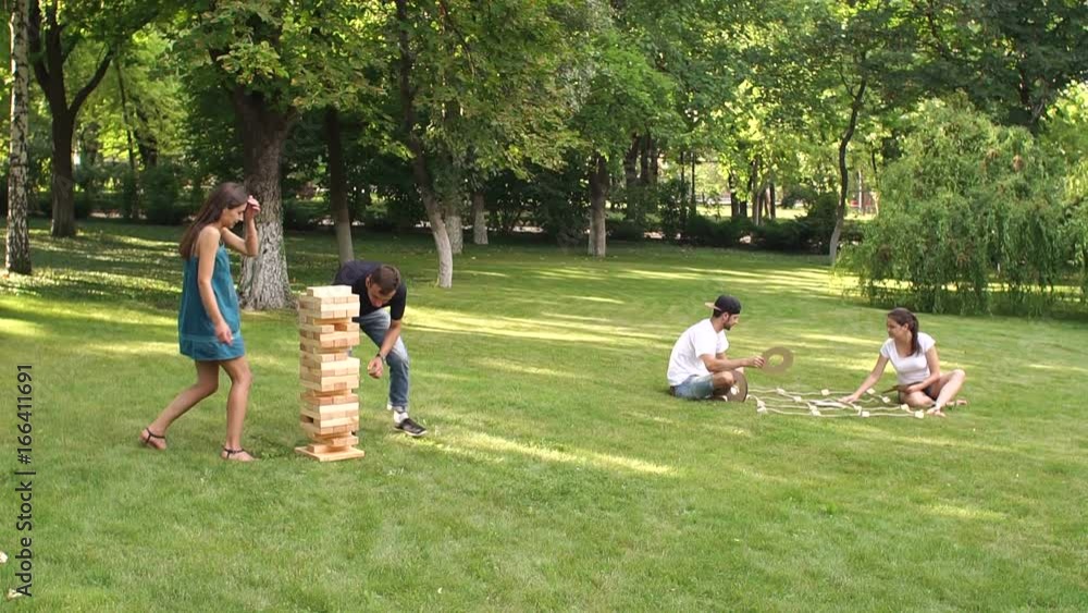Group of young people playing active games in the Park. Big game jenga and tic tac toe outdoor. Group of young people playing active games in the Park. Big game jenga and tic tac toe outdoor.