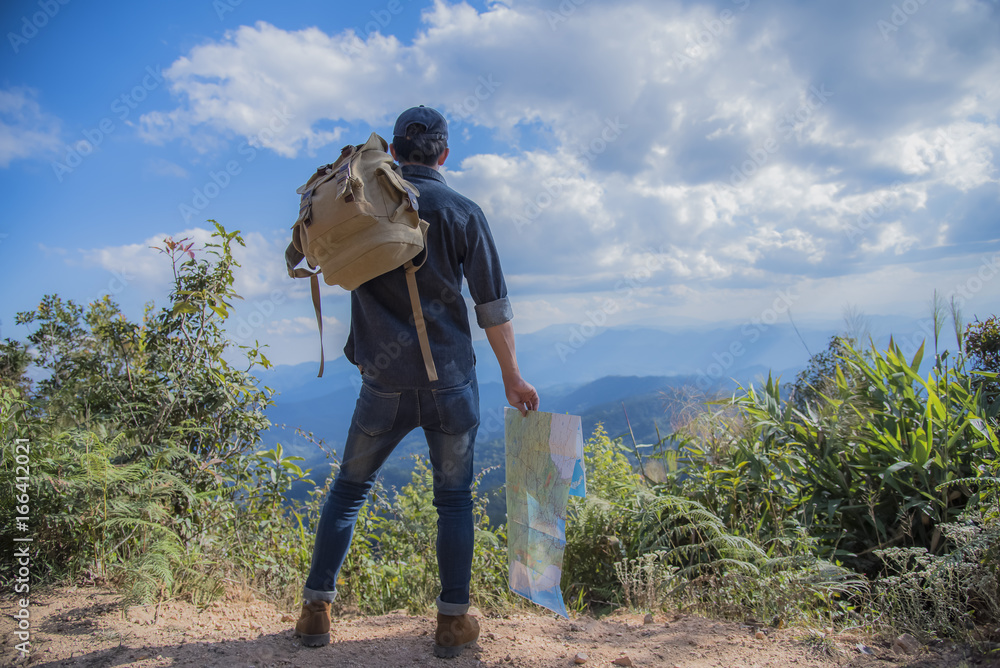 Young Man Traveler with backpack relaxing outdoor with rocky mountains on background Summer vacations and Lifestyle hiking concept.