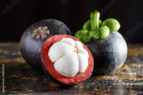 Closeup view of fresh ripe mangosteen on wooden table