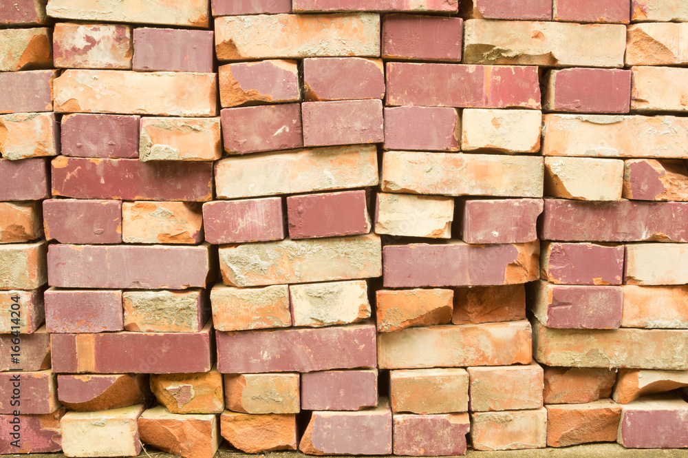 Fototapeta premium Old clay bricks stacked in the wall as a background.
