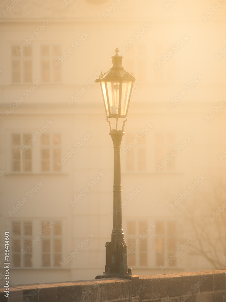 Street lamp on Charles Bridge in foggy morning, Prague, Czech Republic. Sepia image.