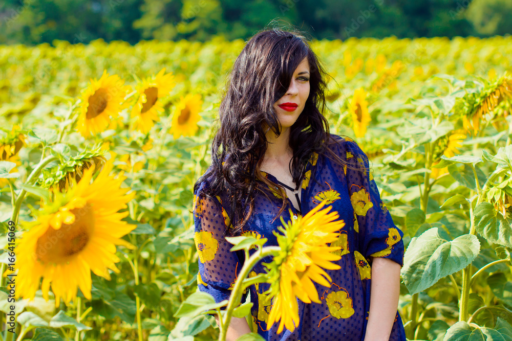 Attractive young brunette curly woman on a sunflowers meadow, on a gold field at good sunny day have a pleasure the life Attractive young brunette curly woman on a sunflowers meadow, on a gold field at good sunny day have a pleasure the life
