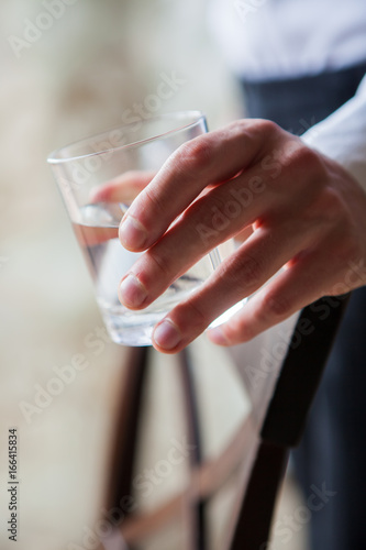 Close up man holding glass of drinking water