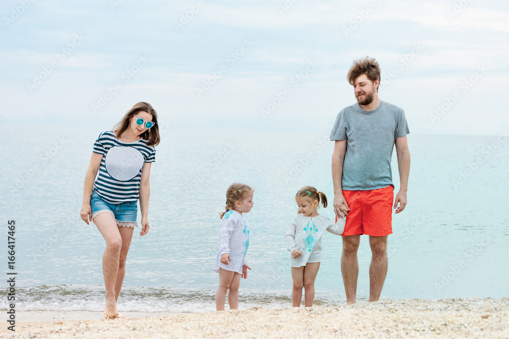 Family vacation parents and children on the sea shore summer day