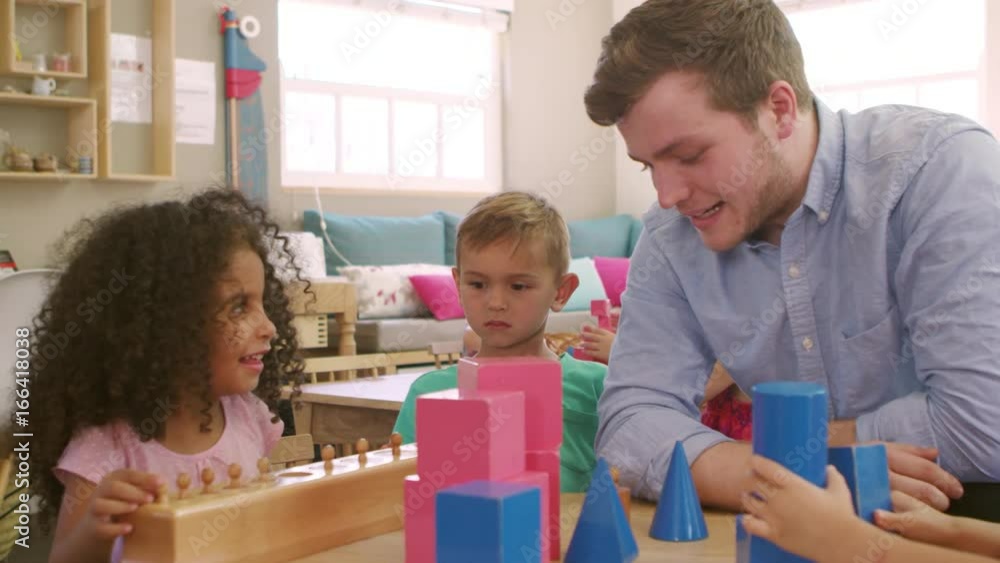Teacher And Pupils Using Wooden Shapes In Montessori School Teacher And Pupils Using Wooden Shapes In Montessori School