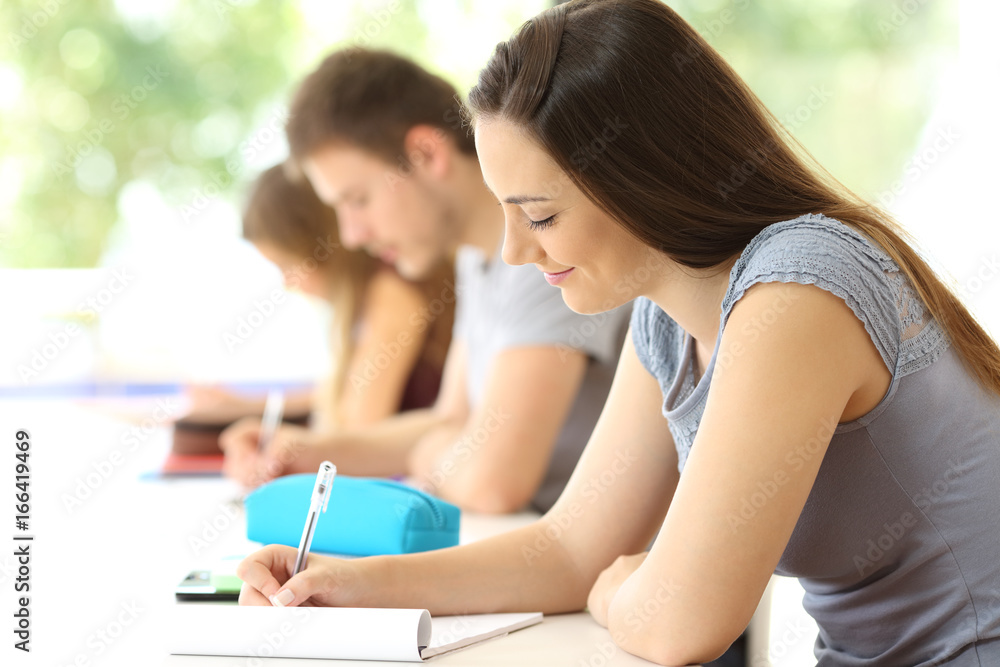 Concentrated student taking notes in a classroom Concentrated student taking notes in a classroom