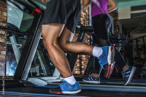 People running in machine treadmill at fitness gym club © Panya Studio