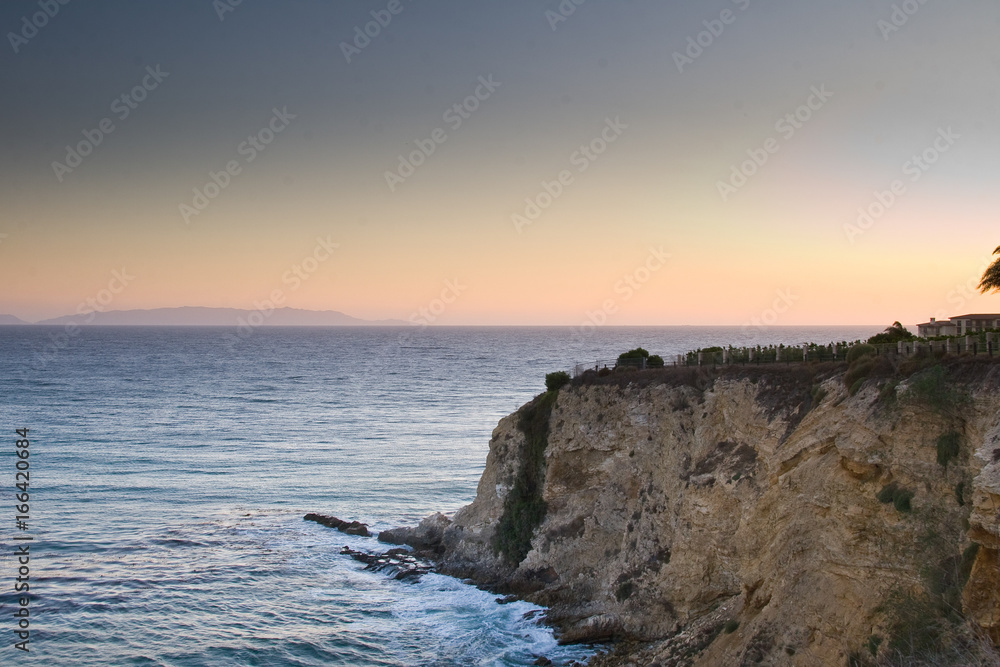 Sunset rises above the rocky California coast