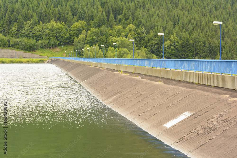 Hydroelectric power dam lined with blue railings and lamps