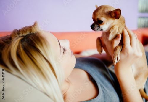 Teenage girl with her dog laying in bed photo