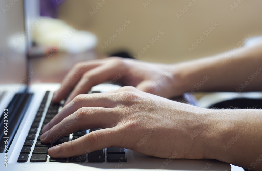 Hand typing on notebook keyboard