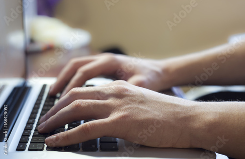 Hand typing on notebook keyboard