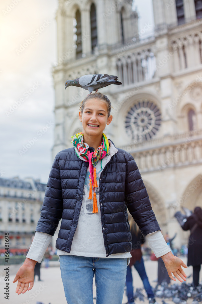 Girl with birds near Notre Dame de Paris cathedral in Paris, France