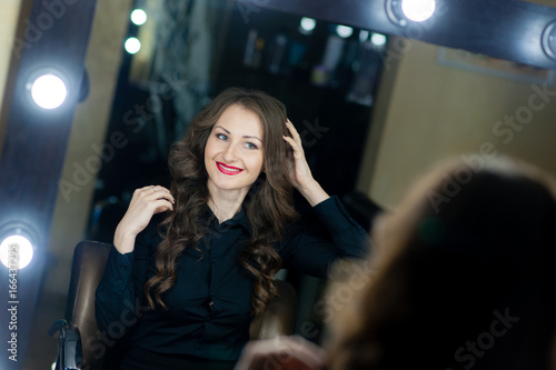 Beautiful girl makeup artist near mirrors