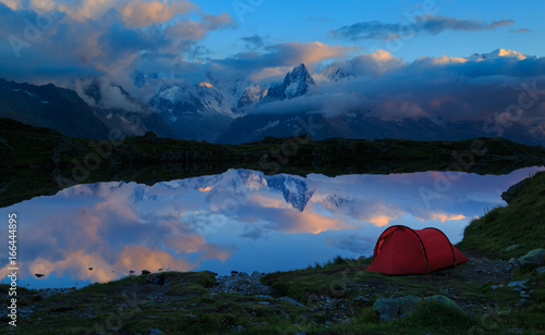 Red tent at Lac des Cheserys in the mountains near Chamonix during dusk. Chamonix, France