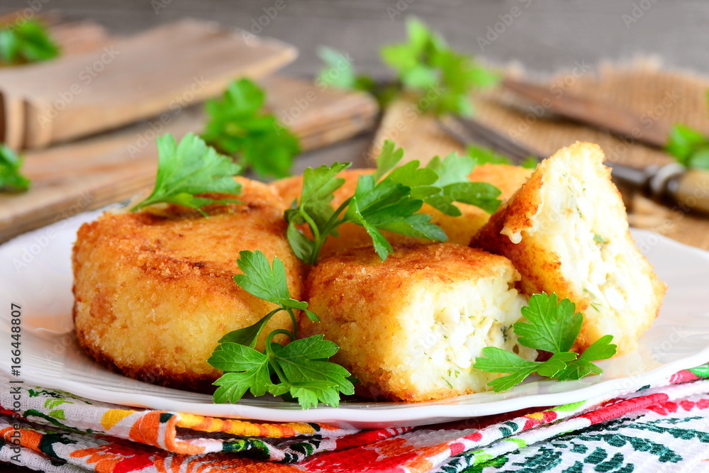Vegetable cakes with eggs on a white plate. Homemade cauliflower and potatoes cakes stuffed with boiled sliced eggs. Rustic style. Closeup Vegetable cakes with eggs on a white plate. Homemade cauliflower and potatoes cakes stuffed with boiled sliced eggs. Rustic style. Closeup