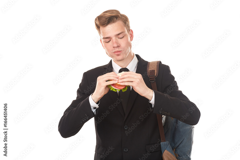 Portrait of college student in black suit eating sandwich against white background Portrait of college student in black suit eating sandwich against white background
