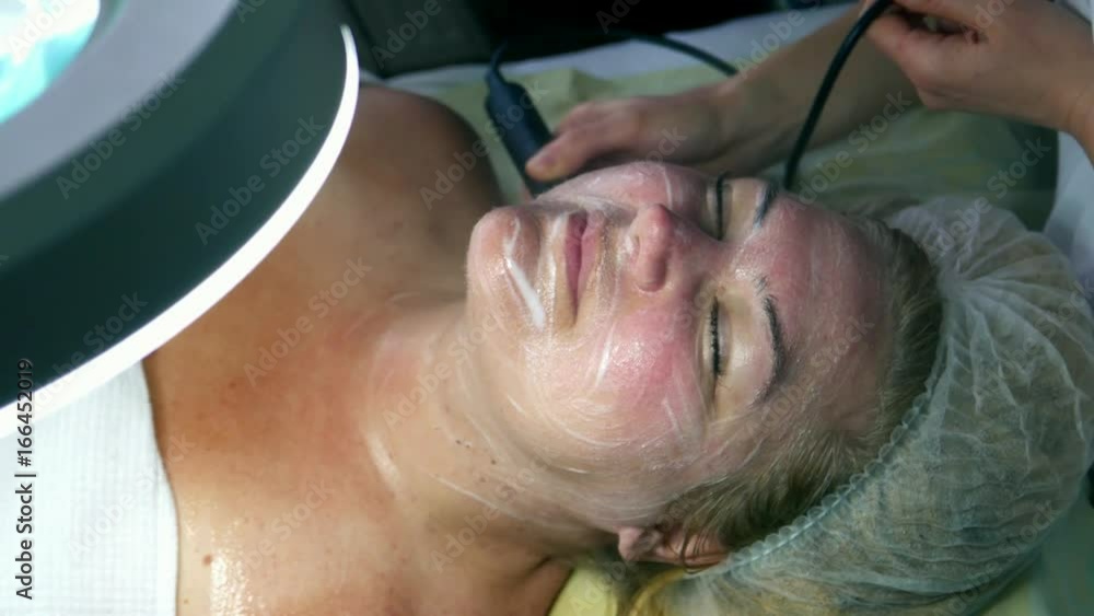 Cosmetology, cosmetic and SPA. A middle-aged woman female on treatment at a cosmetologist. Aging and skin problems. Ultrasound therapy Cosmetology, cosmetic and SPA. A middle-aged woman female on treatment at a cosmetologist. Aging and skin problems. Ultrasound therapy