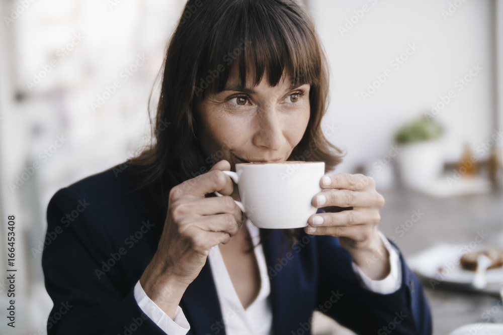 Businesswoman sitting in cafe, drinking coffee Businesswoman sitting in cafe, drinking coffee