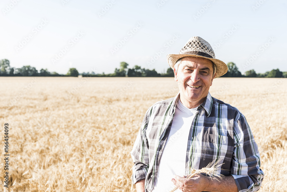 Portrait of laughing senior farmer standing in front of a field Portrait of laughing senior farmer standing in front of a field