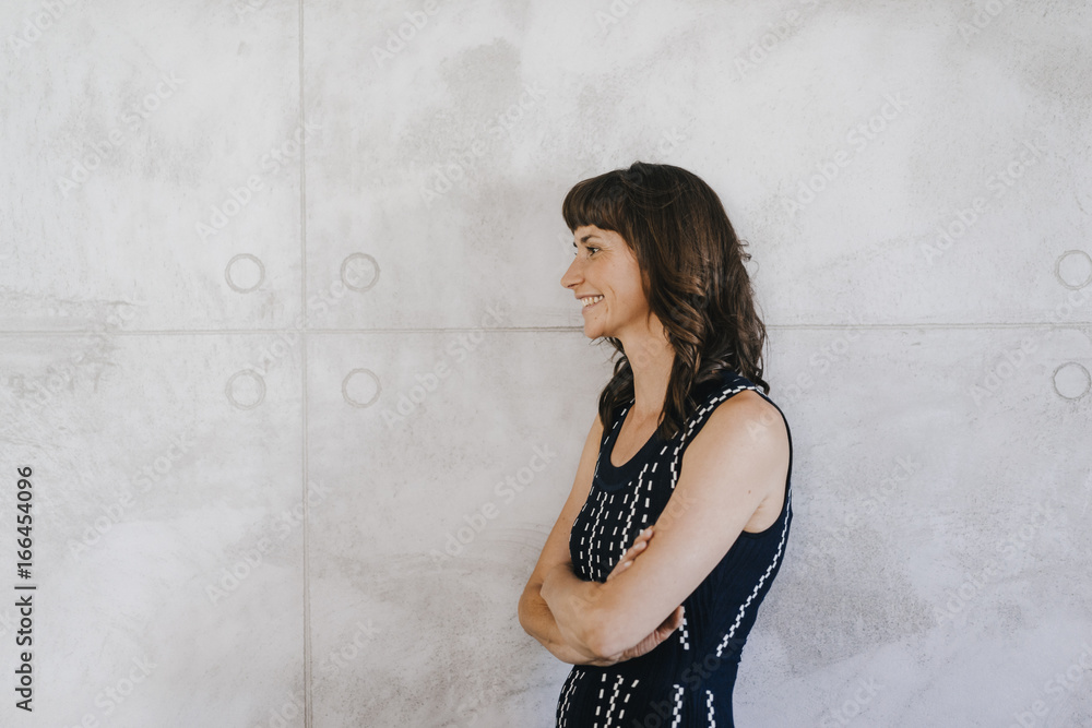 Businesswoman standing in office with arms crossed